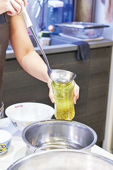 先用攪拌機把全部的清水和黃豆分為5次逐步打磨，或可選擇把一半的清水用於打磨黃豆，剩下的清水在煮豆漿時加入。